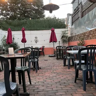 a brick patio with tables and umbrellas