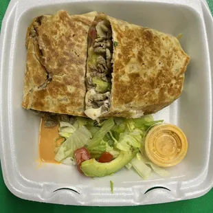 a sandwich and salad in a styrofoam container