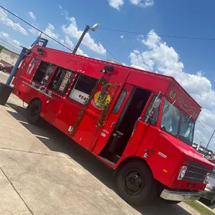 a red food truck parked in a parking lot