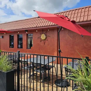 a patio with a red umbrella