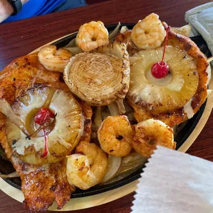 a plate of food with shrimp and pineapples