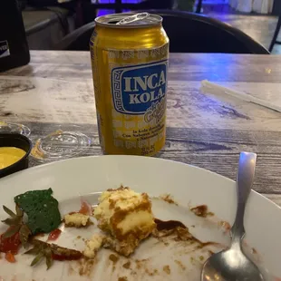 a half eaten plate of food and a can of beer