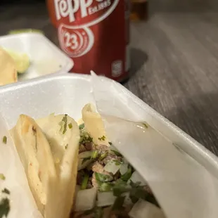 a close up of a taco and a soda