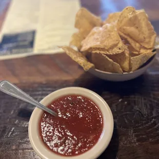 a bowl of salsa and a bowl of tortillas