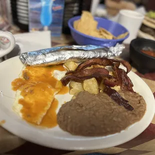 Huevos Rancheros with refried beans, papas and Bacon