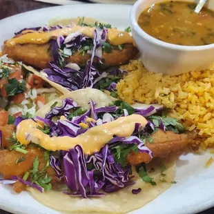 Fish taco with rice, side of salad, and a cup of bean soup.