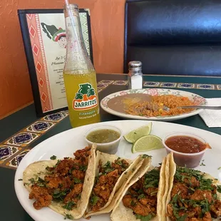 a plate of tacos and a drink