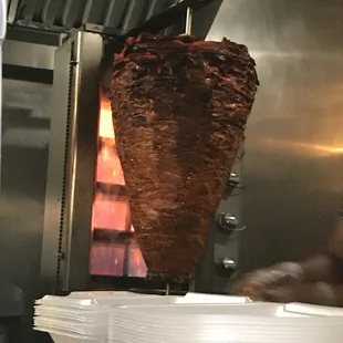 a large kebab being cooked in a commercial kitchen