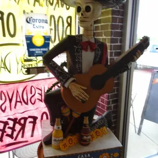 A Modelo beer skeleton watching by the door.