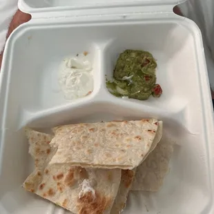 quesadilla, salsa, and sour cream in a styrofoam container