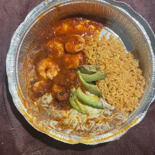 a plate of mexican food with rice and avocado