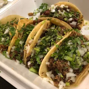 three tacos in a styrofoam container