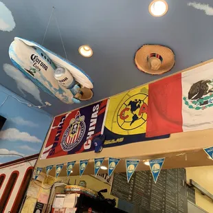 a variety of flags hanging from the ceiling