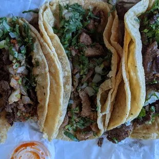 Carne asada tacos on the left and right. Flank steak tacos in the middle