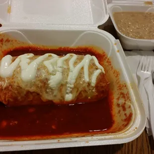 Suizo burrito with red sauce and side of beans to go