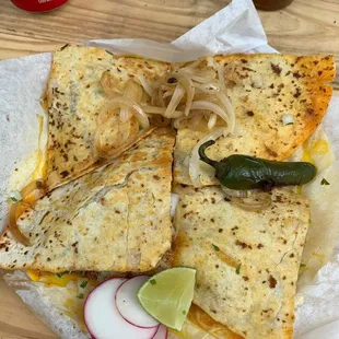 a quesadilla with onions, cheese, and jalapenos