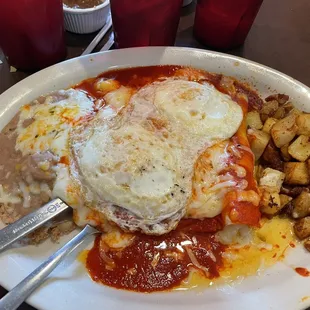 Enchiladas Montadas with red chile, filled with cheese, and over-easy eggs