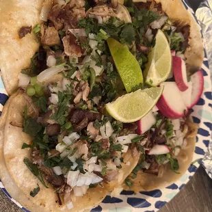 a plate of tacos with a lime wedge