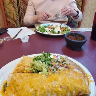 a woman sitting at a table with a plate of food