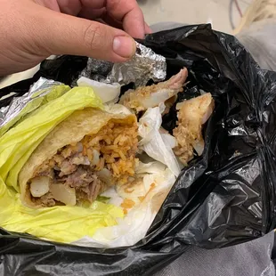 a hand holding a burrito