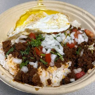 a bowl of rice, meat, and an egg