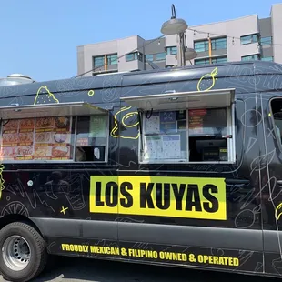 a black food truck parked in front of a building