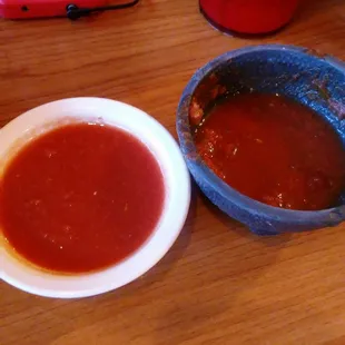 a bowl of tomato sauce next to a bowl of tomato sauce