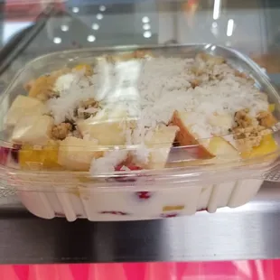a plastic container of fruit and yogurt