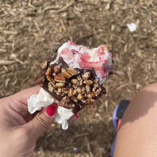 Cream and strawberries covered with chocolate and pecans.