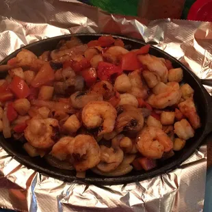 Fajitas del mar - shrimp and scallop fajitas with tortilla, refried bean, guac, lettuce, sour cream, and tomato on the side