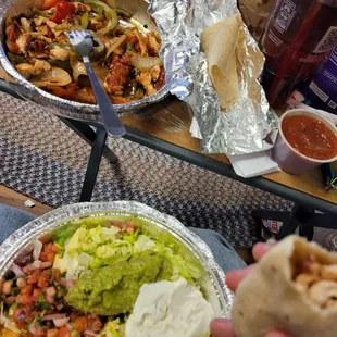 Chicken fajita with a plate of fixings(rice, guacamole, pico de gallo, sour cream, &amp; lettuce), salsa, chips in a bag, and soft tortillas