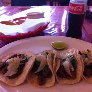 a plate of tacos and a coke