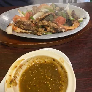 Spicy tomatillo sauce on the side of steak fajitas