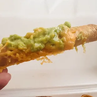 Rolled beef taquito with guacamole and queso