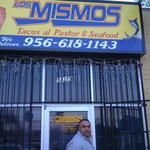 a man standing in front of a restaurant
