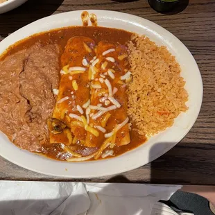 Lunch cheese enchiladas with onions and mushrooms, rice and beans.
