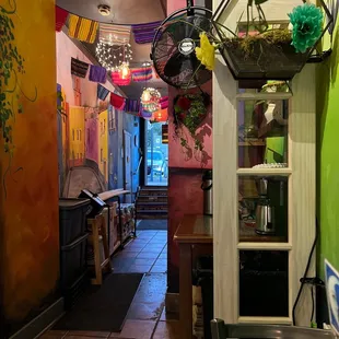 a colorful hallway with tables and umbrellas