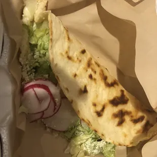 a tortilla with lettuce and radishes