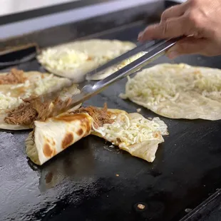 a person cutting a tortilla