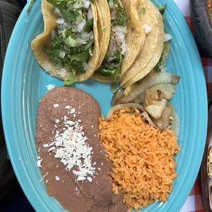 Three tacos with rice and beans