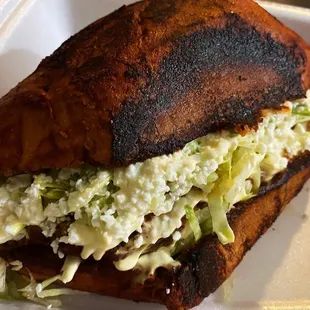 a close up of a sandwich in a styrofoam container