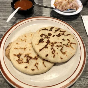Pupusas ($7.50, pork on left, jalapeño on right). Tasty and filling. Red salsa has a kick!