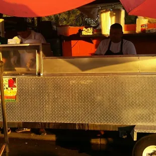 a man behind a food cart