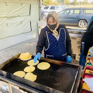 a woman making tortillas