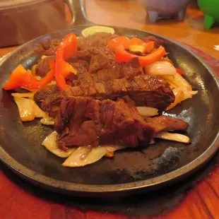 a plate of beef and peppers