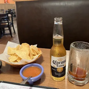 a table with chips and a beer