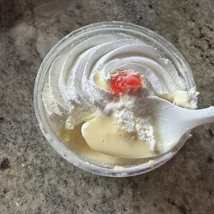 a bowl of whipped cream with a strawberry on top