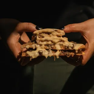 a person holding a cheeseburger