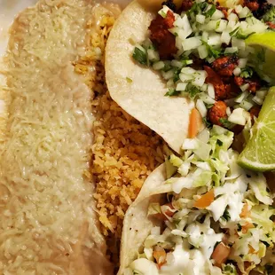Pork adobada and fish tacos with rice and beans