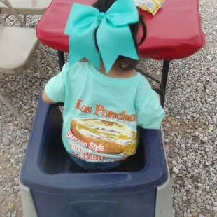 a little girl sitting in a high chair